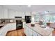 Well lit kitchen with white cabinets, wood floors, granite countertops, and stainless appliances at 1715 Us 15-501 S, Chapel Hill, NC 27517