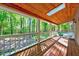 Relaxing covered porch with wooden ceiling, skylight, and views of the surrounding lush greenery at 1715 Us 15-501 S, Chapel Hill, NC 27517