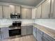 Shows the kitchen's stainless steel appliances, grey cabinetry, granite countertops, and white subway tile backsplash at 1737 Pecan Drive # 21, Nashville, NC 27856