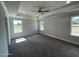 Bright and airy main bedroom featuring tray ceilings, recessed lighting, large windows, and neutral carpet at 1737 Pecan Drive # 21, Nashville, NC 27856