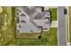 Aerial view of a home with gray roof, manicured lawn, and a paved driveway at 2066 Lake Point Dr, Graham, NC 27253
