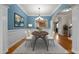 Elegant dining room with blue walls, white trim, hardwood floors, and stylish chandelier at 2066 Lake Point Dr, Graham, NC 27253