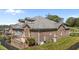 Exterior of the home with brick facade, gray roof, lush lawn, and raised patio at 2066 Lake Point Dr, Graham, NC 27253
