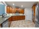 Well-lit kitchen featuring wooden cabinets, tile floors, and modern stainless steel appliances at 2066 Lake Point Dr, Graham, NC 27253