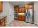 Efficient kitchen layout with wood cabinets, stainless steel refrigerator, oven, and microwave at 2066 Lake Point Dr, Graham, NC 27253