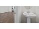 Powder room has a white pedestal sink, mirror, and wood-look flooring at 209 Timber Forest Ln, Cary, NC 27519