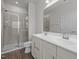 A modern bathroom featuring double sinks, a glass door shower, and white cabinets at 209 Timber Forest Ln, Cary, NC 27519