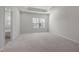 Bright bedroom features a tray ceiling, neutral carpet, and a window for natural light at 209 Timber Forest Ln, Cary, NC 27519