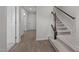 Neutral entryway featuring hardwood floors, carpeted stairs, and a coat closet for storage at 209 Timber Forest Ln, Cary, NC 27519
