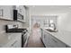 Modern kitchen featuring white cabinets, stainless steel appliances, an island, and a sliding glass door at 209 Timber Forest Ln, Cary, NC 27519