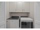 Laundry room with side by side washer and dryer and storage cabinets at 209 Timber Forest Ln, Cary, NC 27519