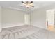 Open main bedroom with carpet, ceiling fan, and en suite bathroom access at 2103 Glenkirk Dr, Burlington, NC 27215