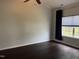 Cozy bedroom with a ceiling fan, hardwood floors, and a large window with a blue curtain at 2124 Claret Ln, Morrisville, NC 27560