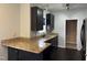 Modern kitchen with stainless steel sink, granite countertops, and black cabinets at 2124 Claret Ln, Morrisville, NC 27560