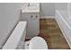 An efficient bathroom setup with hardwood floors, a sink vanity, toilet, and a tub and shower combination at 213 Dwelling Pl, Knightdale, NC 27545