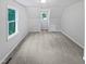 Bright bedroom featuring neutral carpet, fresh paint, and natural light from two windows at 213 Dwelling Pl, Knightdale, NC 27545