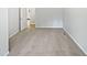 Empty bedroom featuring carpeted floors and white walls, leading into a bright hallway at 213 Dwelling Pl, Knightdale, NC 27545