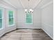 The dining room features hardwood floors, modern lighting, and many windows that provide bright, natural light at 213 Dwelling Pl, Knightdale, NC 27545