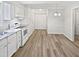 Open-concept kitchen with all-white cabinets, stainless steel sink, and modern flooring at 213 Dwelling Pl, Knightdale, NC 27545