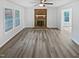 Bright and spacious living room with vinyl plank flooring, a brick fireplace and big windows at 213 Dwelling Pl, Knightdale, NC 27545