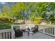 Cozy back deck surrounded by mature trees, featuring comfortable outdoor furniture perfect for relaxing and entertaining at 213 Meadow Fox Rd, Holly Springs, NC 27540