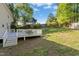 Spacious backyard with a white deck, lawn, and mature trees, perfect for outdoor enjoyment and activities at 213 Meadow Fox Rd, Holly Springs, NC 27540