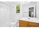 Well-lit bathroom with a wooden vanity, tub, and shower combination, plus a large mirror to enhance the space at 213 Meadow Fox Rd, Holly Springs, NC 27540