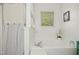Bright bathroom featuring a soaking tub, neutral paint, and striped shower curtain for a clean, modern aesthetic at 213 Meadow Fox Rd, Holly Springs, NC 27540