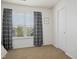 Sunlit bedroom showcasing neutral decor, carpeted floors, and a large window, perfect for a tranquil space at 213 Meadow Fox Rd, Holly Springs, NC 27540