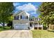 Charming two-story home with a front-facing two-car garage, well-manicured lawn, and mature trees at 213 Meadow Fox Rd, Holly Springs, NC 27540