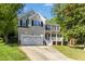 Charming two-story home featuring an attached two-car garage, and a welcoming front porch at 213 Meadow Fox Rd, Holly Springs, NC 27540