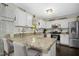 Well-equipped kitchen featuring stainless steel appliances, granite countertops, and white cabinets with breakfast bar at 213 Meadow Fox Rd, Holly Springs, NC 27540