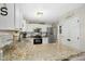 Bright kitchen features granite countertops, stainless steel appliances, and white cabinetry at 213 Meadow Fox Rd, Holly Springs, NC 27540