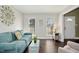 Bright living room with hardwood floors, a comfortable sofa, and ample natural light from the two windows at 213 Meadow Fox Rd, Holly Springs, NC 27540