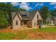An attractive home features brickwork and a unique roof, complemented by lush green surroundings at 2305 Ballywater Lea Way, Wake Forest, NC 27587