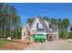 Two-story home featuring mixed siding and brick exterior under construction with a steeply pitched roof and a blue sky backdrop at 2305 Ballywater Lea Way, Wake Forest, NC 27587