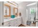 Bright bathroom with double vanity, white cabinets, and wood framed mirrors at 262 Windgate Dr, Clayton, NC 27527