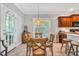 Sunlit dining area featuring a round glass table with wood chairs and a decorative barrel at 262 Windgate Dr, Clayton, NC 27527