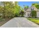 Long driveway leading to a two-car garage, surrounded by mature trees and lush greenery at 262 Windgate Dr, Clayton, NC 27527