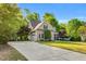 Traditional home boasting a well-manicured lawn, mature trees, and a long driveway leading to a two-car garage at 262 Windgate Dr, Clayton, NC 27527