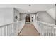 Well-lit hallway with white railing and carpet, leading to various rooms at 262 Windgate Dr, Clayton, NC 27527