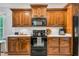 Close-up of kitchen featuring dark wood cabinets, white countertops, and black appliances at 262 Windgate Dr, Clayton, NC 27527