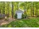 Backyard shed surrounded by lush greenery and vibrant trees at 262 Windgate Dr, Clayton, NC 27527