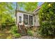 Cozy screened sunroom accessible by wooden steps overlooks the beautiful backyard landscape at 262 Windgate Dr, Clayton, NC 27527