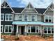 A modern two-story townhouse under construction with gray siding, black roof, and white trim, showcasing contemporary design at 3022 White Rail Dr, Fuquay Varina, NC 27526