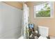 Bathroom featuring a shower/tub combo with flower curtain, toilet, and a window at 304 Cedarwood Ln, Carrboro, NC 27510