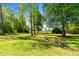 Expansive backyard featuring a gentle creek and mature trees providing ample shade and privacy at 308 Thorndale Dr, Dunn, NC 28334