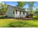 The back of the house shows a deck, brick patio, and large windows. A serene place to relax at 308 Thorndale Dr, Dunn, NC 28334