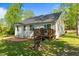 A view of the house, from the backyard, featuring a wooden deck, brick patio, and firepit area at 308 Thorndale Dr, Dunn, NC 28334