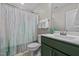 Bathroom with a toilet, tub and shower combo, vanity with a green cabinet, sink, and mirror at 308 Thorndale Dr, Dunn, NC 28334